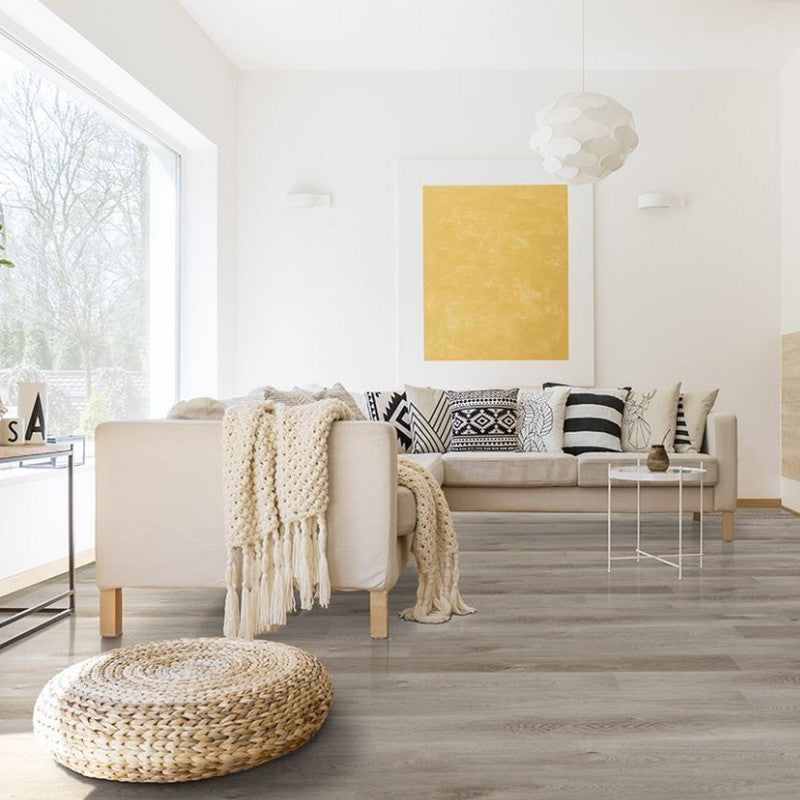 Image is showing a Living Room, with a big Yellow Game, A fancy geometric hanging pendant, and a L-shaped sofa with Pillows, and Side Tables.