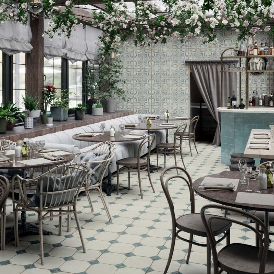 Image is displaying a outdoor sitting areawith many sofas, and dining chairm and tables, Image also have Pironda icker TIles on walls and floors